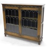 A Priory style oak bookcase, with a pair of astragal glazed doors on block feet, 108cm high, 124cm
