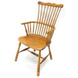 A comb top Windsor chair, with a double vertical spindle back, 'C' shaped arms, shaped saddle seat