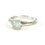 A 9ct white gold solitaire ring, with claw set paste stone, flanked by small white stones, size Q,