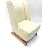 An early 20thC wingback rocking chair, in later floral material, on a shaped rocker base, 95cm high,