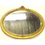 A 20thC giltwood mirror, of oval form, surmounted by a shell and scroll moulding, with a beaded