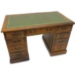 A late 19th/early 20thC oak pedestal desk, the rectangular top with a green tooled leather insert
