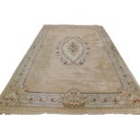 A large Indian carpet, with a central medallion decorated with flowers around a cartouche on a beige