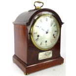 An early 20thC walnut and mahogany dome top bracket clock, the shaped case with gilt metal handle on