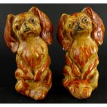 A pair of plaster figures of standing King Charles Spaniels, each in orange and yellow colourway,