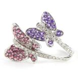 An elaborate 9ct gold dress ring, set with two butterflies, each with purple and pink stones, with