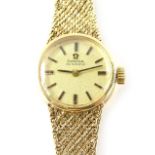 A 9ct gold Omega ladies wristwatch, with small circular watch head, on bark effect bracelet, with