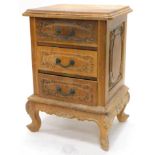 A late 19thC French walnut bedside cabinet, with three heavily carved drawers with heavy handles, on