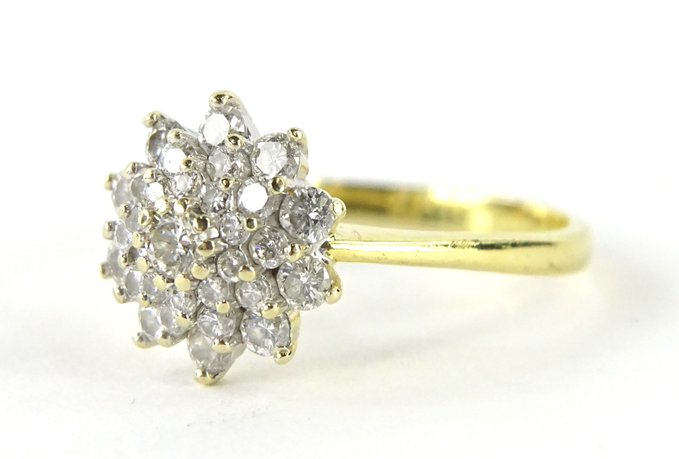 An 18ct gold diamond cluster ring, florally set with an arrangement of nineteen diamonds, central