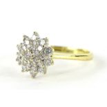 An 18ct gold diamond cluster ring, florally set with an arrangement of nineteen diamonds, central