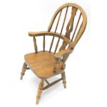 A 20thC oak high back child's Windsor chair, with pierced splat and turned legs, joined by a 'H'