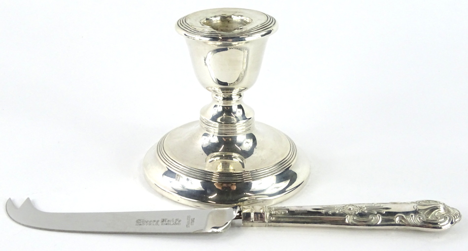 An Elizabeth II silver handled cheese knife, stylised kings pattern with shaped blade marked