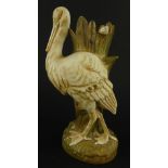A Crown Devon Fieldings stork spill vase, in gilt and yellow, printed marks beneath, 26cm high, (