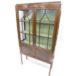 An Edwardian mahogany display cabinet, with caddy top, raised above a pair of astragal glazed doors,