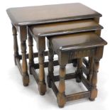 A nest of three Ercol style dark wood tables, each with oblong tops on turned legs, 40cm high,