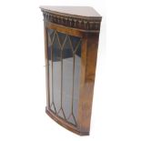 A 20thC George III style walnut hanging corner cupboard, with an astragal glazed door, serpentine