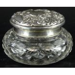 An Elizabeth II silver and cut glass powder box, the lid heavily repousse decorated with scrolls,