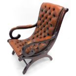 A 20thC mahogany framed scroll library armchair, with brown button back leather to the back and