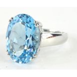 A 9ct white gold chunky dress ring, claw set with a large blue stone, on a part pierced shank,
