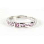 A 9ct white gold half eternity ring, set with pink stones, size M, 2g all in.