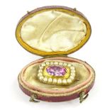 A 19thC brooch, centred by a raised oval pink topaz, surrounded by small pearls, with a plain pin