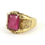 A 9ct gold dress ring, claw set with a rectangular pink coloured seal stone, set with a figure