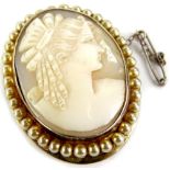 A silver framed shell cameo brooch, the shell cameo of maiden facing dexter, (AF), with a faux pearl