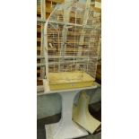 A meshwork dome topped bird cage on stand, 145cm high, 51cm wide, 28cm deep.