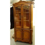 A freestanding corner cupboard, with double cupboard beneath, on shaped stiles, 191cm high, 83cm