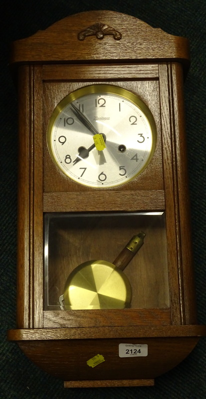 A late 20thC Kieninger wall clock, in shaped case, with glass door and circular Arabic dial, with