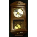 A late 20thC Kieninger wall clock, in shaped case, with glass door and circular Arabic dial, with