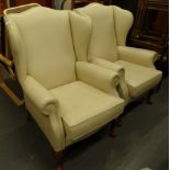 A pair of modern wing armchairs, with shaped tops, removable cushion seats and squat front