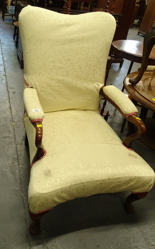 A walnut open armchair in the George III style, the cream damask padded back arm rest and seat