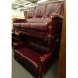 A two piece lounge suite comprising three seater and two seater settees in crimson leather, 183cm