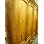 A pine triple door wardrobe with two drawers beneath, 200cm high, 164cm wide, 68cm deep. *Option