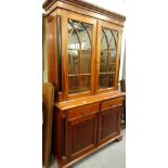 A mahogany bookcase in George III style, the top with a moulded cornice above two glazed doors,