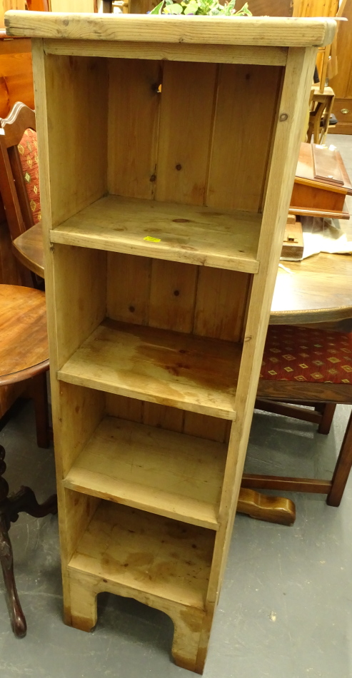 A pine narrow cabinet, set with four open shelves, on shaped block feet, 122cm high, 37cm wide, 25cm