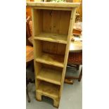 A pine narrow cabinet, set with four open shelves, on shaped block feet, 122cm high, 37cm wide, 25cm