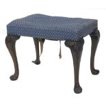 A walnut rectangular stool in George III style, with a padded seat on cabriole legs headed by carved