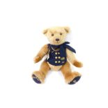 A Harrods Millennium plush jointed teddy bear 2000, with blue bow and blue jacket with gilt coloured