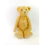 A Steiff plush jointed teddy bear, with button to ear and label to body, 58cm high.