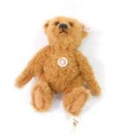 A Steiff plush jointed teddy bear, in brown with growl action, label to the ear, 32cm high.