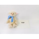 A Steiff Royal Baby plush jointed teddy bear George, in white, with blue bow, label to the ear,