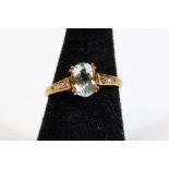 A dress ring, claw set with oval aquamarine coloured stone with small diamonds to the shoulders,