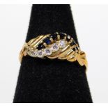 A 9ct gold dress ring, crossover claw set with white and blue stones, size N-O, 2.5g all in.