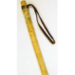 A Japanese cosh or club, of cylindrical form, with turned material body and leather strap handle,
