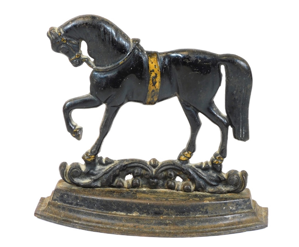 A 20thC cast iron door stop, in the form of a horse, on a stepped base, with pierced scroll stand,