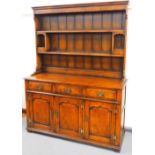 A 20thC Stanley Cumper oak dresser, the upper section with Delft racking above open cupboards with