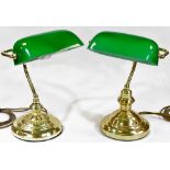 A matched pair of desk lights, each with articulated green shades on shaped stems and stepped