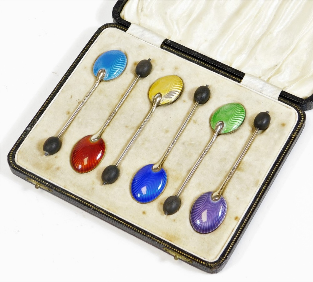 A set of six silver and enamel bean spoons, to include dark blue, light blue, etc. with bean tops,